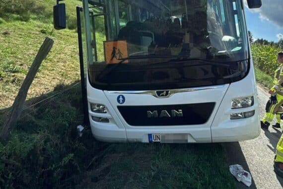 Schulbus liegt im Straßengraben; Polizei am Unfallort (Archivfoto).
