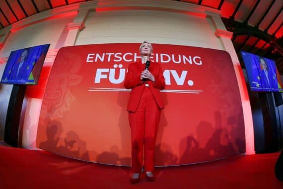 Manuela Schwesig jubelnd bei der SPD-Wahlparty in Schwerin, mit Wahlergebnis im Hintergrund.