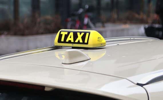 Gelbes Taxi im Stadtverkehr (Archiv), Diskussion um hohe Taxipreise in deutschen Großstädten.