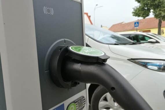 Eine Stromtankstelle für ein E-Auto (Archivfoto), im Hintergrund das Auto, Umweltfreundlichkeit im Fokus.