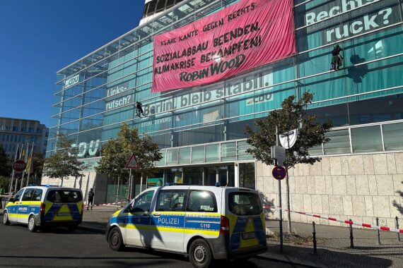 Umweltaktivisten seilen sich vom Dach der CDU-Zentrale ab und entrollen ein Transparent in Berlin.