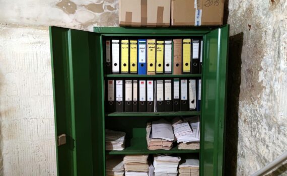 Ein Aktenschrank im Archiv, der Bürokratie und Regulierung als Wirtschaftsproblem symbolisiert.