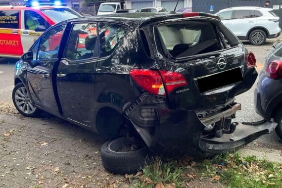 Beschädigter Pkw und Motorrad an der Unfallstelle auf der Hingbergstraße, Feuerwehr und Einsatzfahrzeuge.