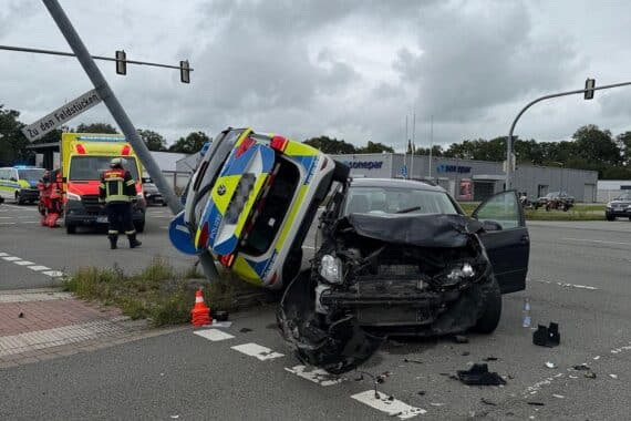 Polizeiwagen liegt zwischen Laternenmast und Unfall-Pkw nach Zusammenstoß in Aurich.