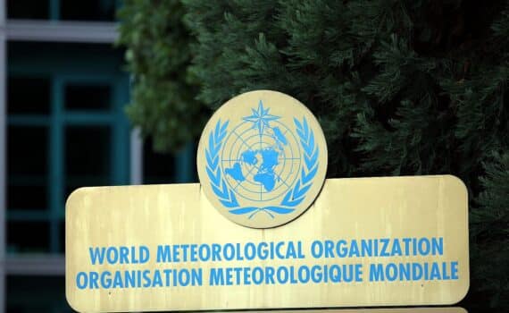 Genf: WMO-Gebäude, Trockenheit und wechselnde Flüsse symbolisiert, Gletscher schmelzen im Hintergrund.