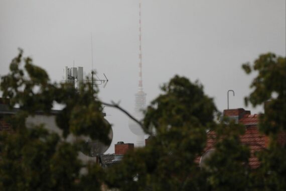Berliner Fernsehturm bei wechselhaftem Wetter: starke Wolken, Regen-/Schauerstimmung über Berlin.
