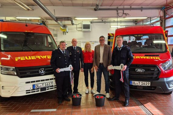 Übergabe neuer Mannschaftstransportwagen an Feuerwehr und Jugendfeuerwehr Hude, Politiker und Einsatzkräfte mit Fahrzeugschlüsseln.