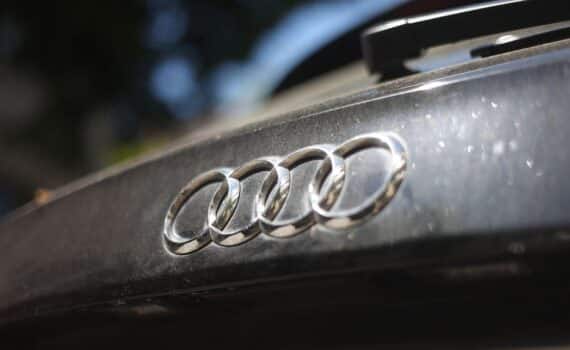 Ein Audi-Fahrzeug mit deutlich sichtbarem Markenlogo als Symbol für den Gewinneinbruch des Automobilherstellers.