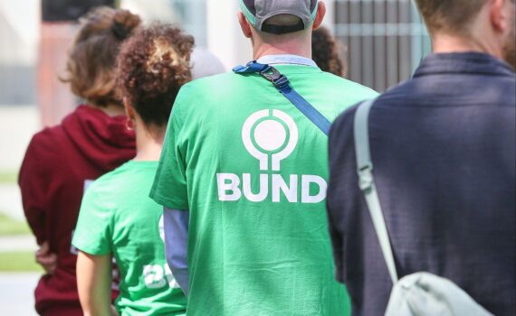 Das BUND-Logo auf einem Schild als Symbol für den Einsatz zum Schutz der biologischen Vielfalt.