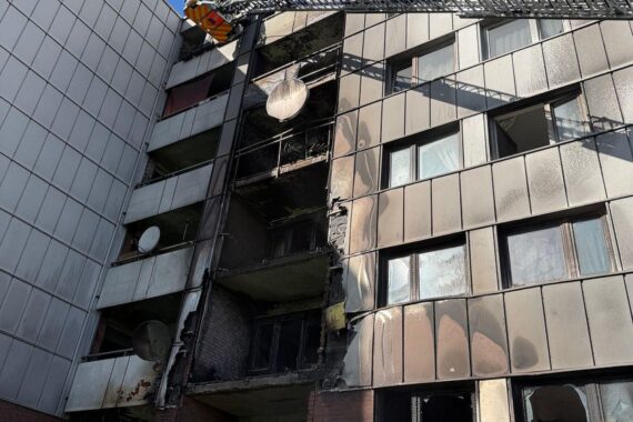 Brand in Mehrfamilienhaus in Bonn: Flammen und Rauch an rückwärtiger Fassade, Feuerwehr im Einsatz.