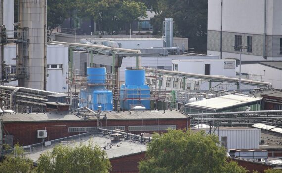 Chemieanlagen im Hintergrund; VCI-Warnung vor Reformen, in schwarz-rotem Politik-Kontext.