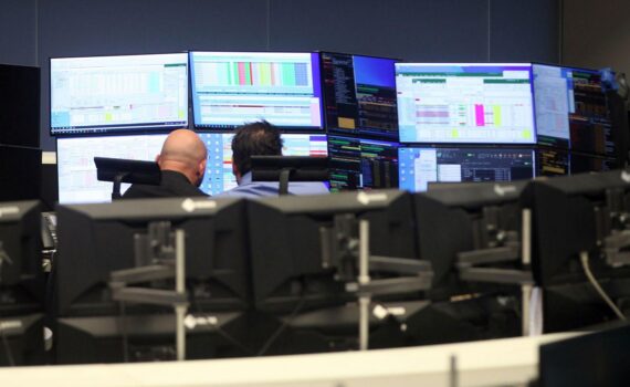 Frankfurter Börse mit DAX-Anstieg: Kurse grün, Analystenkommentar, im Hintergrund Aktienmarkt und Börsentafel.