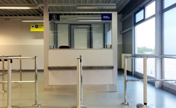 Flughafen-Kontrolle mit Passkontrolle: Beamte prüfen Reisende; Thema sind Visa-Rückgänge für Russen.
