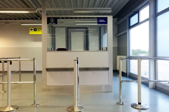 Flughafen-Kontrolle mit Passkontrolle: Beamte prüfen Reisende; Thema sind Visa-Rückgänge für Russen.