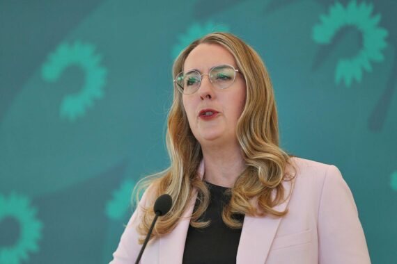 Katharina Dröge bei einer politischen Rede, mit ernstem Gesichtsausdruck vor neutralem Hintergrund.