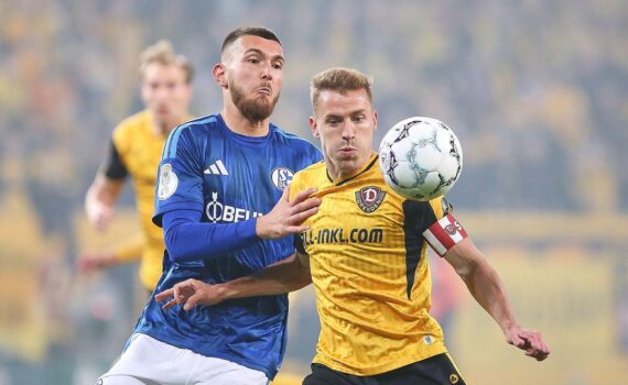 Jubelnde Dynamo-Dresden-Spieler nach dem 2:0-Pokalsieg gegen Schalke 04, enttäuschte Schalker im Hintergrund.