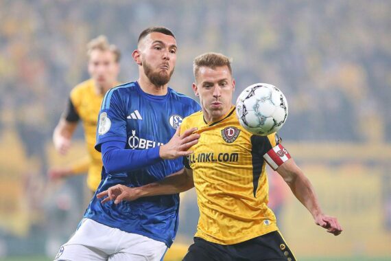 Jubelnde Dynamo-Dresden-Spieler nach dem 2:0-Pokalsieg gegen Schalke 04, enttäuschte Schalker im Hintergrund.