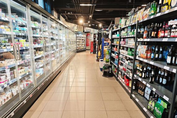 Ein Supermarkt mit Einkaufskörben und Preisschildern; Inflation im Euroraum im Fokus.
