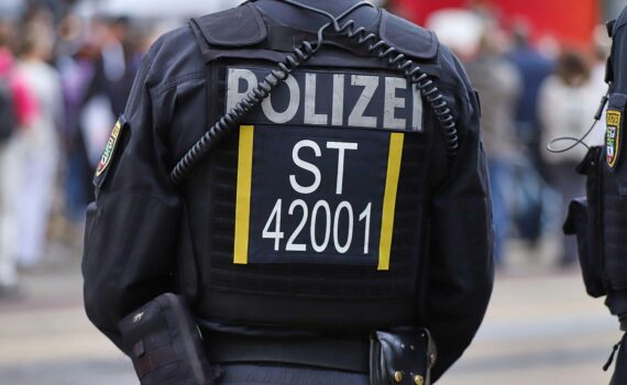 Uniformierte Polizeikräfte sichern eine Demonstration mit jungen Teilnehmenden auf einer Berliner Straße.