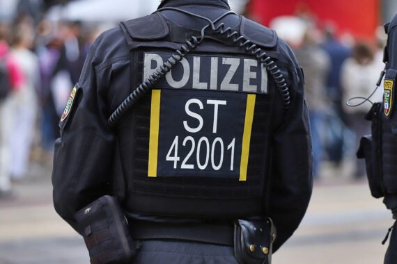 Uniformierte Polizeikräfte sichern eine Demonstration mit jungen Teilnehmenden auf einer Berliner Straße.
