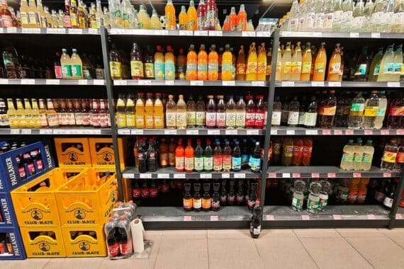 Mehrere Limonaden im Supermarktregal, Verbraucherpreise steigen wegen geplanter Zuckersteuer.