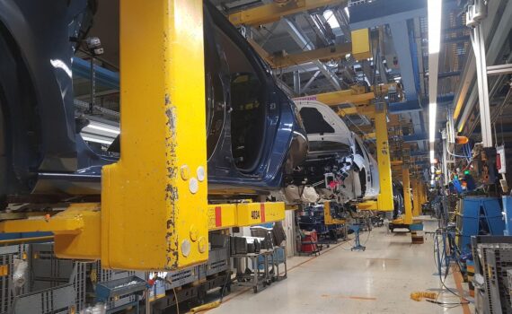 Autoproduktion in einer deutschen Fabrik mit Fahrzeugen am Fließband als Symbol für steigende Unternehmenspreise.