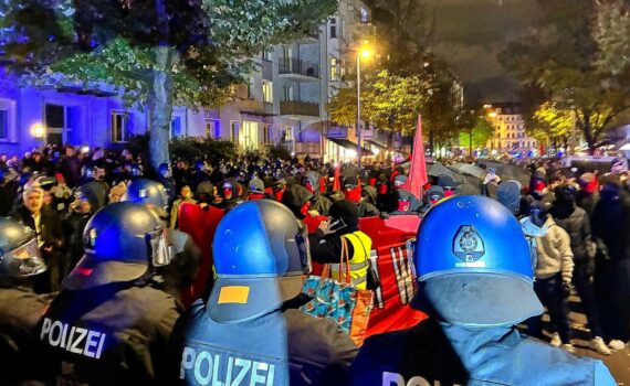 Demonstrierende bei einem „Gen Z regelt“-Protest auf einer Straße, begleitet von zahlreichen Polizeikräften.