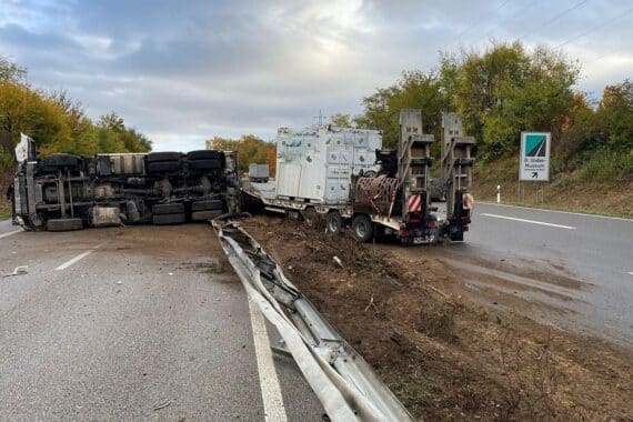 Umgekippter Lkw auf der B9 bei Germersheim, daneben die durchbrochene Mittelleitplanke.