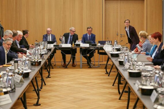Mitglieder der Pflegestrukturkommission bei ihrer konstituierenden Sitzung an einem Konferenztisch in Berlin.