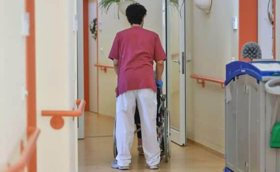Eine Hauswirtschaftskraft unterstützt eine pflegebedürftige ältere Person bei alltäglichen Aufgaben im Haushalt.