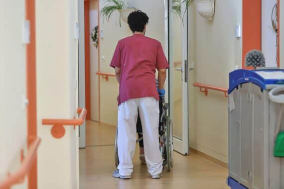 Eine Hauswirtschaftskraft unterstützt eine pflegebedürftige ältere Person bei alltäglichen Aufgaben im Haushalt.