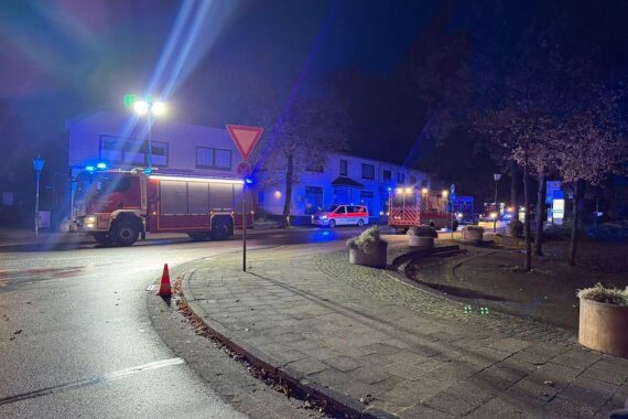 Feuerwehr im nächtlichen Löscheinsatz vor einer Sozialunterkunft in Sittensen, Rauch dringt aus einem Fenster.