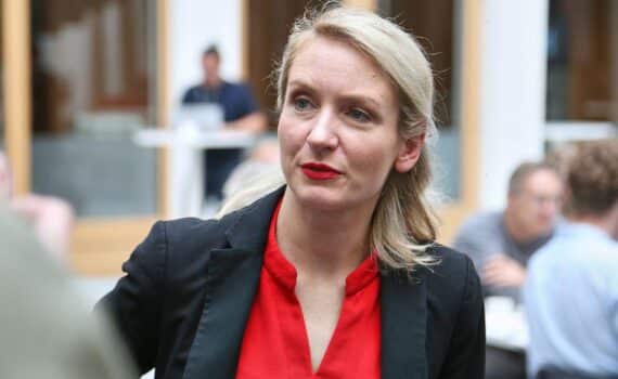 Ines Schwerdtner im Archivfoto; im Hintergrund friedliche Proteste in Frankreich, ohne Gewalt.