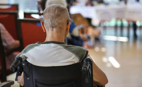 Mann im Rollstuhl im Pflegeheim (Archiv) — Streit um Pflegekommission beigelegt.