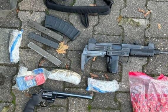 Von der Polizei sichergestellte Schusswaffen, Bargeld und Drogen, übersichtlich als Beweismittel ausgelegt.