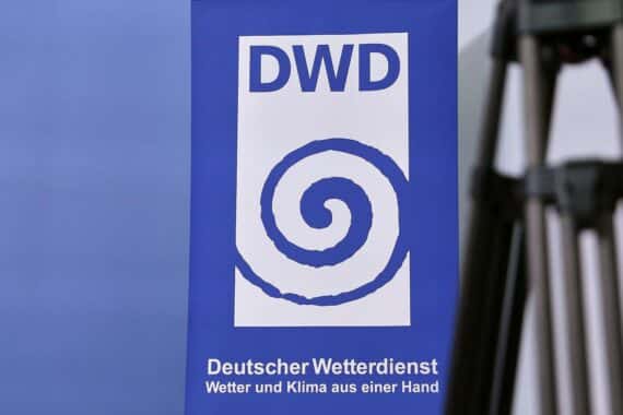 Sturmwindige, stark bewölkte Küste mit Regen- und Gewitter-Schauern; DWD-Logo im Archiv-Kontext.